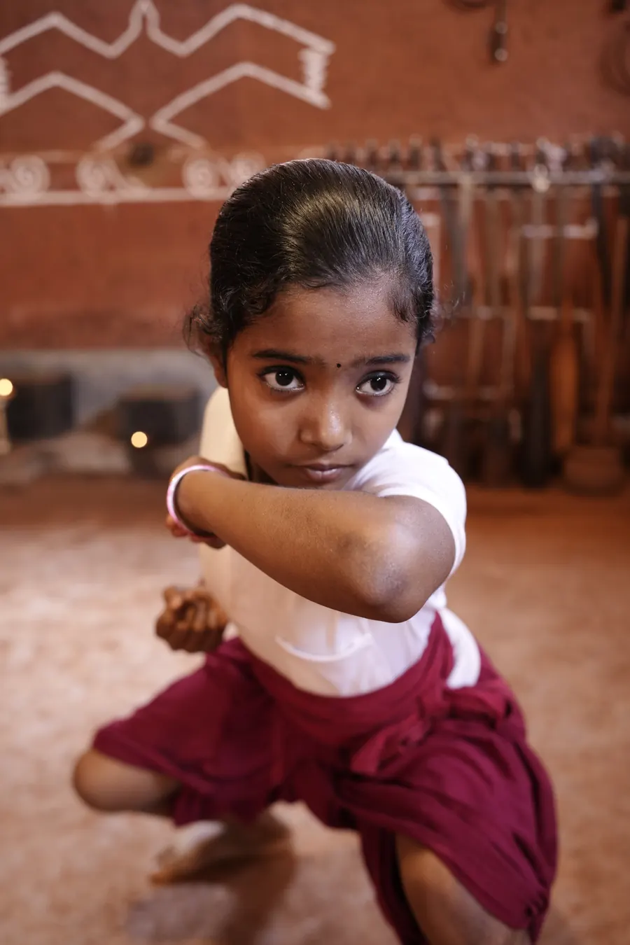 A young student holding a fighting stance in the kalari