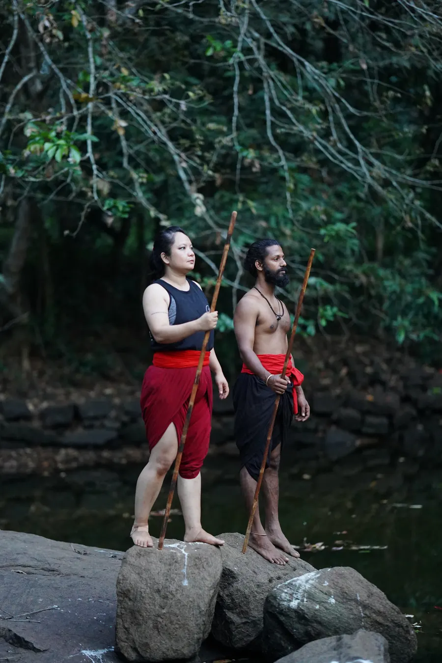2 students in a fighting stance on the rocks by the river