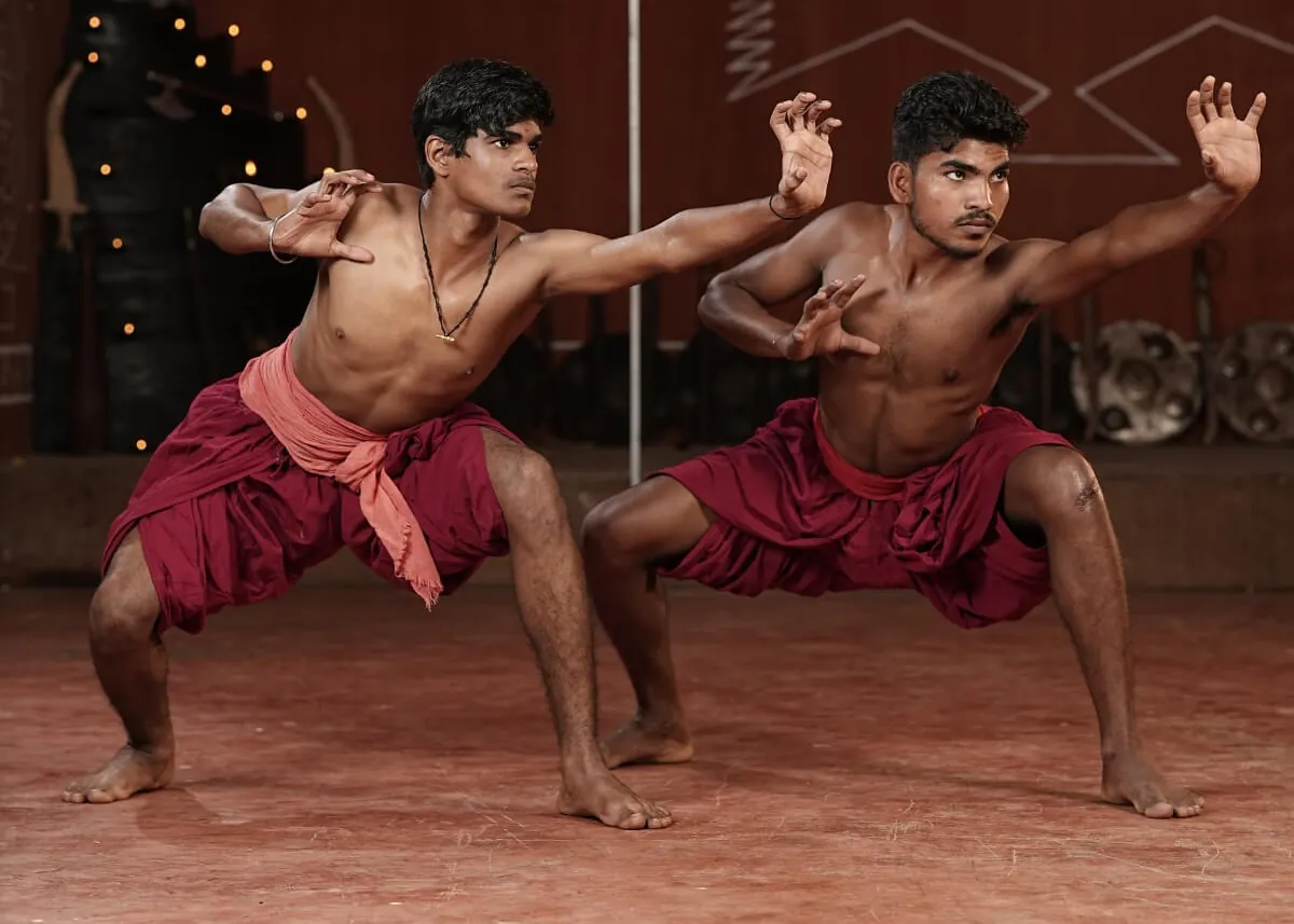 2 Kalaripayattu students holding a stance together